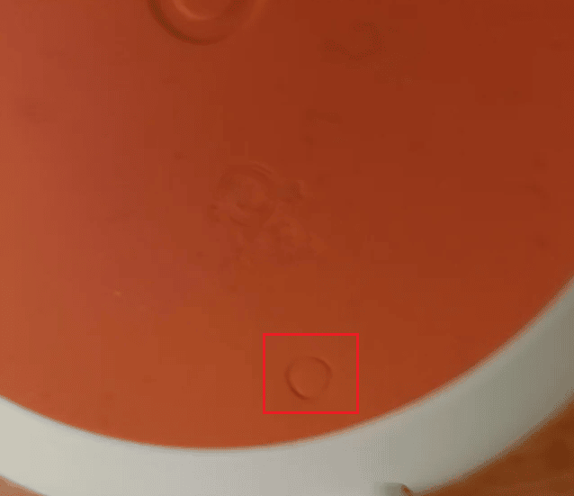 factory reset button (engraved circle) on Google Home Mini device